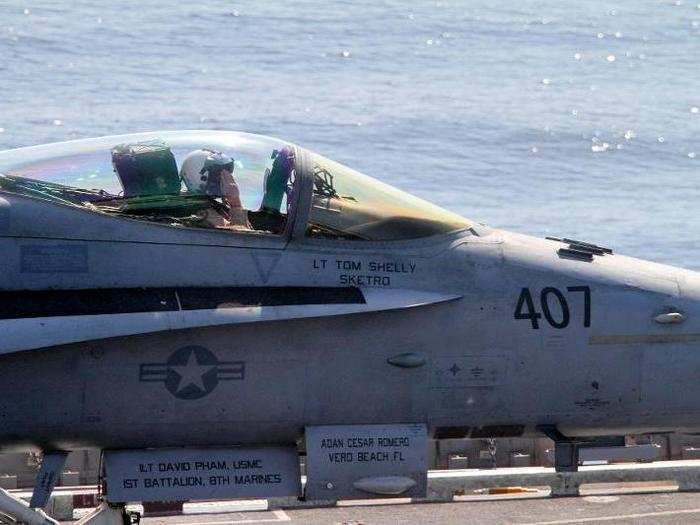 Zooming in, we can see pilot Lt. Tom Shelly giving his ground crew a crisp salute.