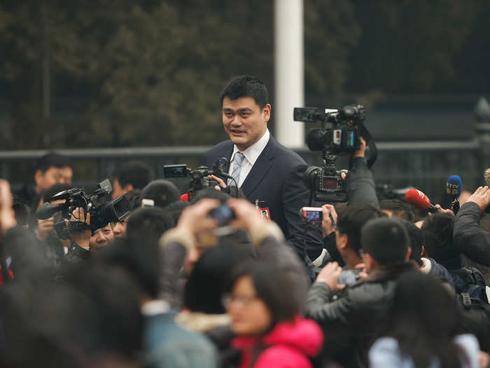 In a sea of reporters and photographers, Ming looks like a mountain peaking up through the clouds.