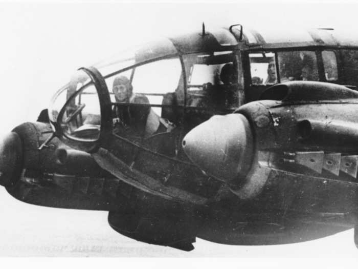 The forward machine gunner is seen sitting at his battle position in the nose of a German Heinkel He 111 bomber plane, while en route to England in November 1940.