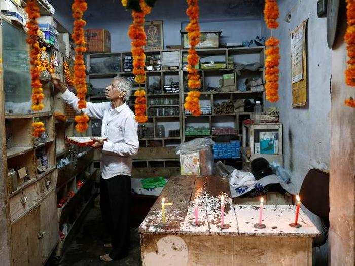 An elderly man offers sweets to an image of Hindu Goddess Lakshmi during Diwali festival in New Delhi, India on Sunday.