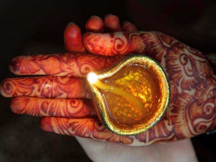 A woman from the Hindu community holds an earthen oil lamp while taking part in a ceremony to celebrate Diwali at Krishna temple, in Lahore, Pakistan on Sunday.