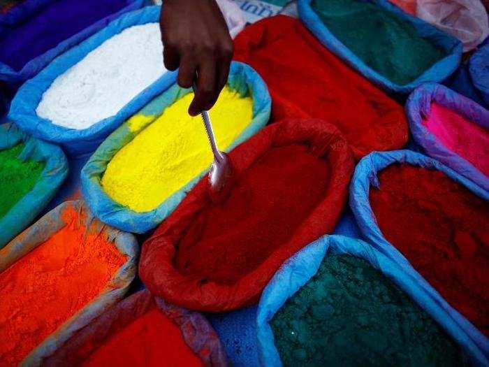 A street vendor spreads vermilion powder used for worship during the Tihar festival, also called Diwali, in Kathmandu, Nepal.