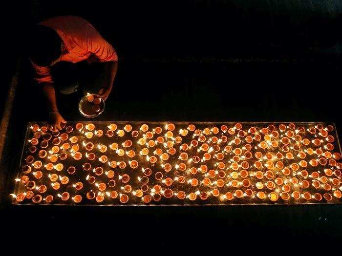 A Tamil devotee lights oil lamps at a religious ceremony during the Diwali or Deepavali festival at Ponnambalavaneshwaram Hindu temple in Colombo, Sri Lanka.