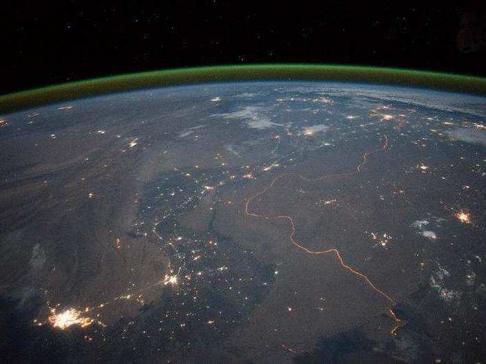 The floodlit India-Pakistan border is visible as an orange glow.