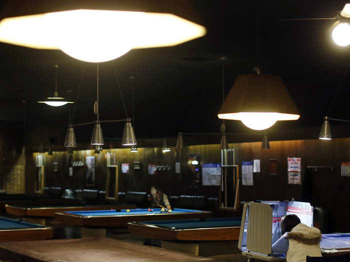 A voter sits in a voting booth at a billiards hall used as a polling station in Chicago, Illinois.