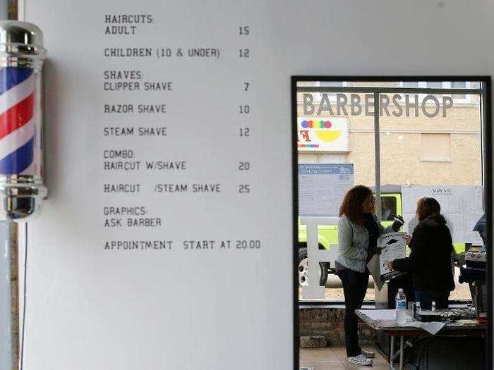 A voter hands over her ballot to an elections worker at a barber shop used as a polling station in Chicago, Illinois.