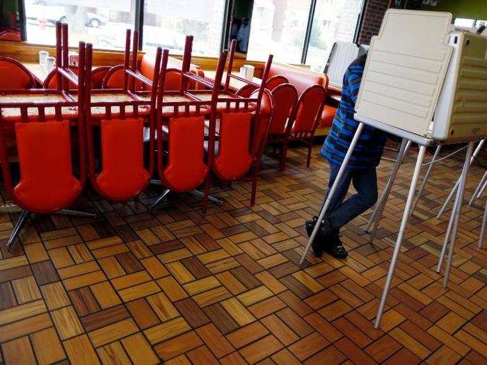 A voter stands in a voting booth at a restaurant used as a polling station in Chicago, Illinois.