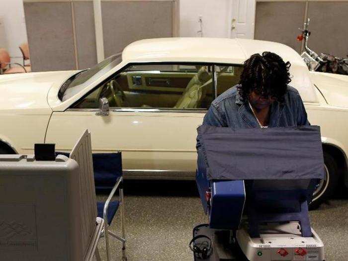 A voter casts her ballot in the US midterm elections at a car dealership used as a polling station in Chicago, Illinois.