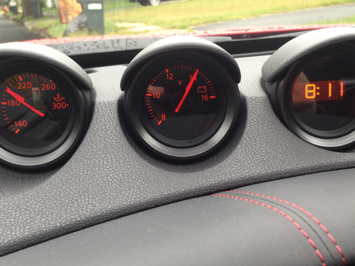 A trio of additional gauges is embedded in the dash. One of them is a kind of cheap-looking digital clock.