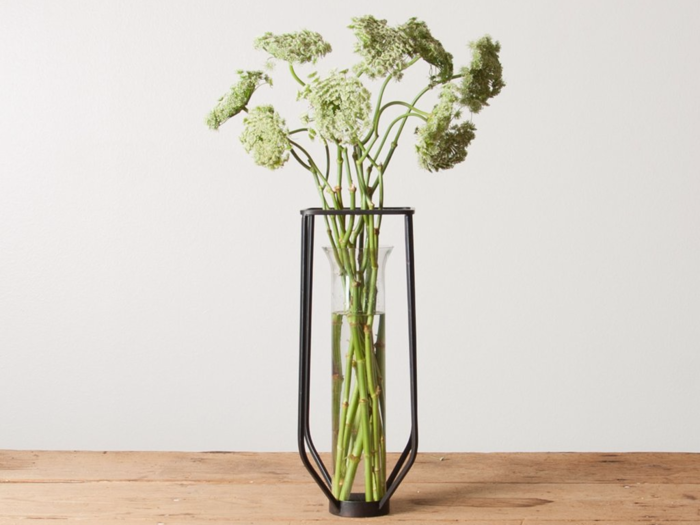 This playful vase adds visually interesting details, from the vial to the metal frame.