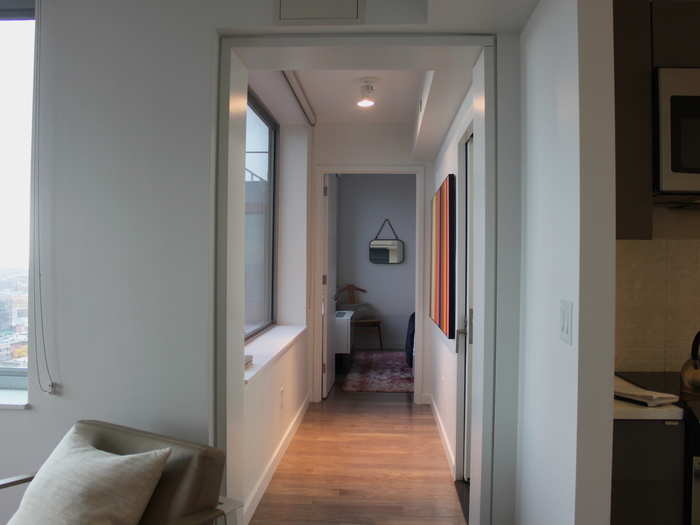 The bedroom is located off a hallway that connects to the living room.