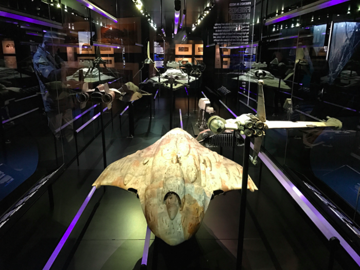 A giant glass case is filled with spaceships from the original trilogy. It