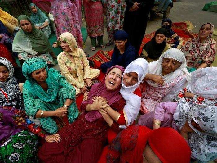 Relatives of Irfan Ahmed, who, according to local media died after being hit by a tear gas canister fired by security forces, mourn his death in Srinagar as the city remains under curfew following weeks of violence in Kashmir on August 22.