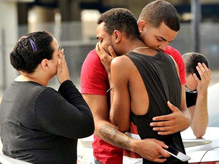 Friends and family members embrace outside the Orlando Police Headquarters during the investigation of a shooting at Pulse nightclub, where 49 people were murdered during the US