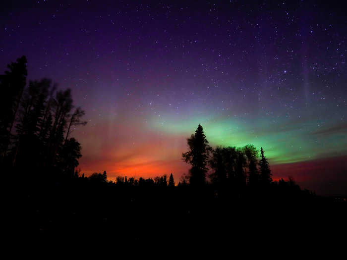 Wildfires glow underneath The Northern Lights, also known as the Aurora Borealis, near Fort McMurray, Alberta, Canada, on May 7.