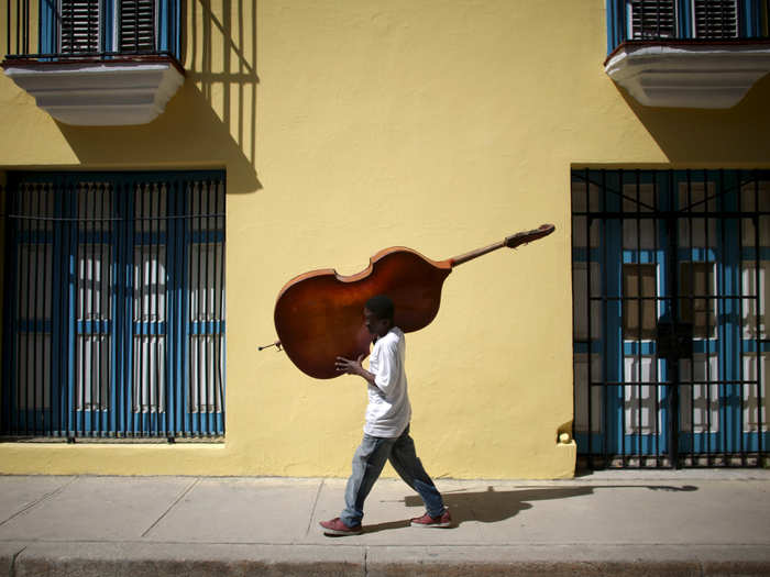 Musician Frilal Ortiz carries a double bass in downtown Havana, on March 16.