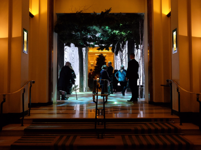 The unfurnished firs are accompanied by a lobby bedecked to look like a winter wonderland. Fake snow lines the floor alongside real tree trunks, under a leafy canopy and shifting light-scheme.