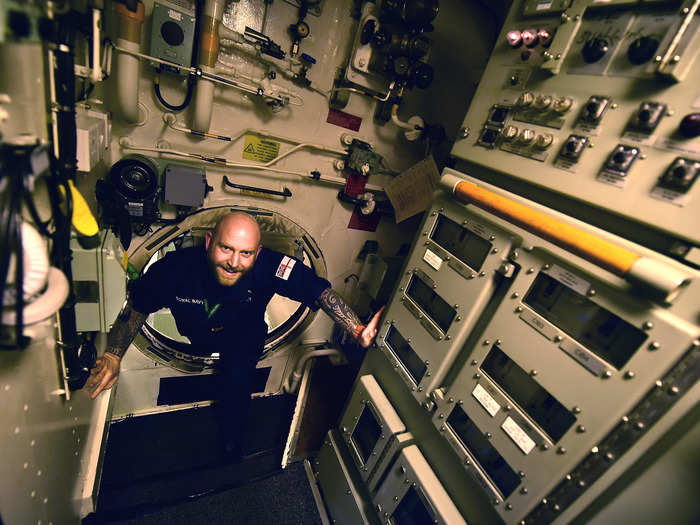 A sailor making his way through a hatch.