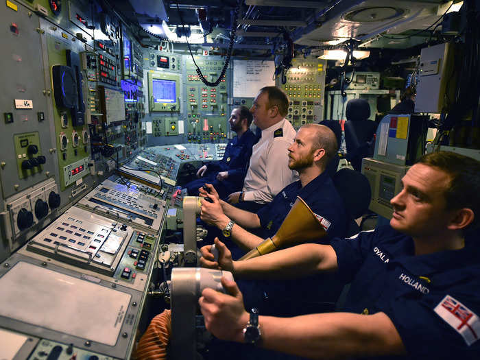 Royal navy personnel executing their duties inside the control room on the Vigilant.