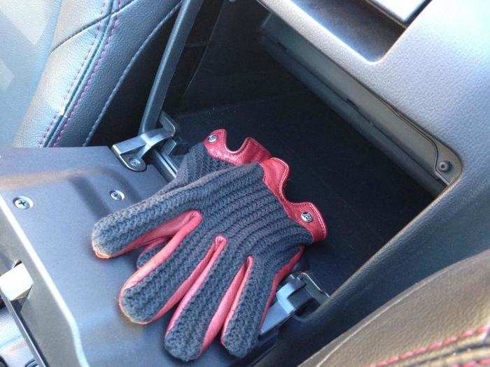 The glove compartment is between the seats, behind the driver and passenger — and just about large enough to handle an actual pair of gloves.