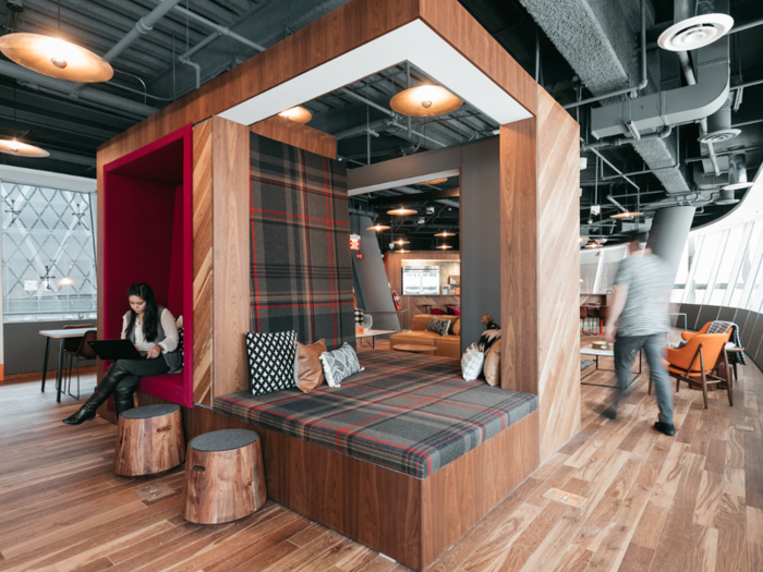 The reading nooks are housed in this cube in a central part of the office, complete with plenty of pillows and rustic foot stools.