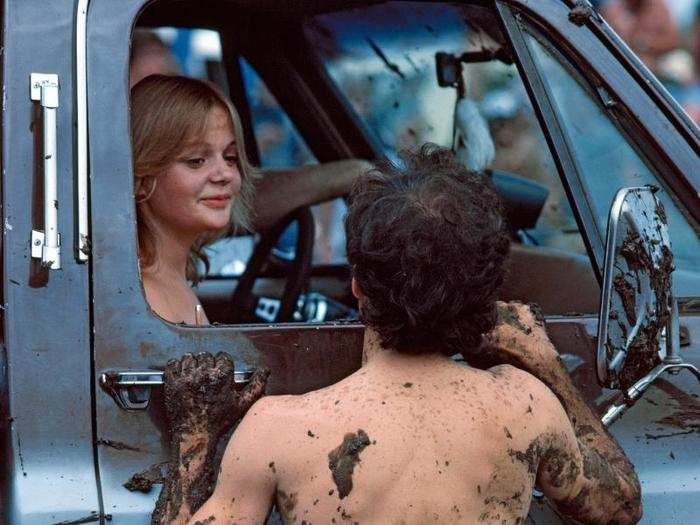 Oklahoma, 1983: They love their mud in Tulsa, where various sports, motor and otherwise, take place in the mire. Here the winner of a mud footrace converses with the occupant of a pickup, which displays its own battle splatter.