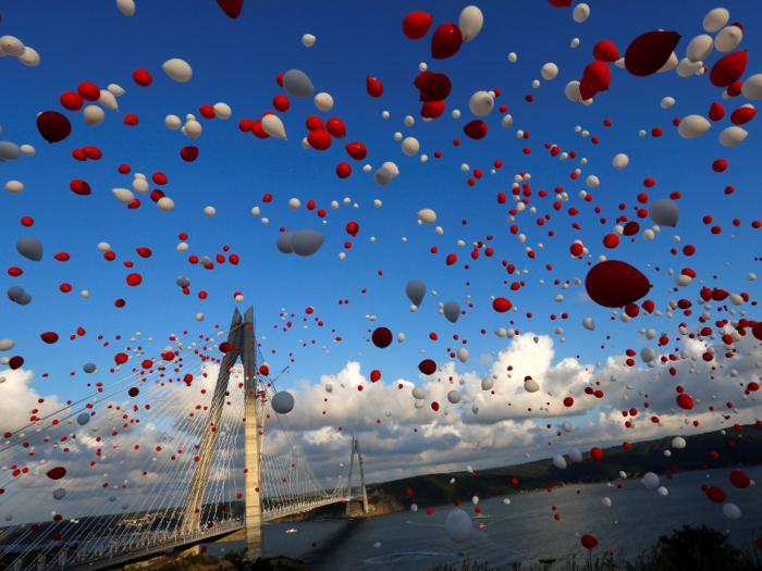 Red and white balloons are released during the opening ceremony of newly built Yavuz Sultan Selim bridge, the third bridge over the Bosphorus linking the city