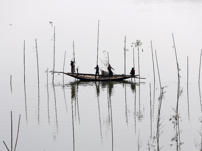 Fishermen on a river in Dhaka, Bangladesh.