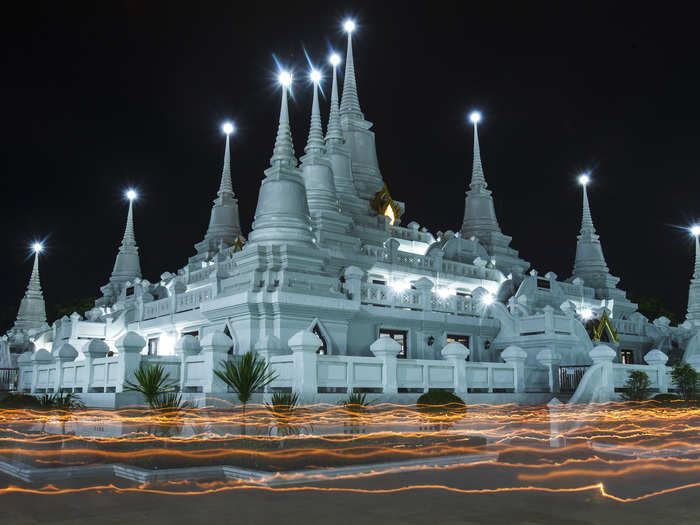 In Samut Prakan, Thailand, a custom involves Buddhist monks circling the Wat Asokaram temple with candles.