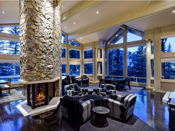 This home has a large, open living space with floor-to-ceiling windows and one dramatic fireplace.