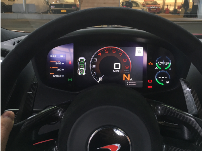 The center screen displays road speed, engine RPM, gear selection, and the posted speed limit. The left screen displays the trip computer while the right screen displays the engine