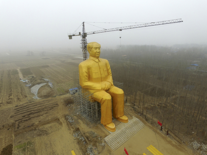 A crane is seen next to a giant statue of Chinese late chairman Mao Zedong under construction near crop fields in a village of Tongxu county, China. The 36 metre-high statue was quickly torn down because it lacked state approval.