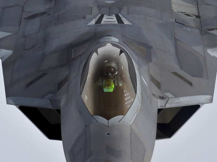A pilot looks up from a U.S. F-22 Raptor fighter as it prepares to refuel in mid-air with a KC-135 refuelling plane over European airspace during a flight to Britain from Mihail Kogalniceanu air base in Romania.