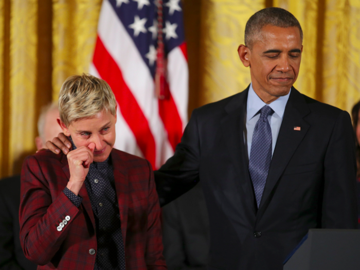 Comedian and talk show host Ellen DeGeneres wipes away a tear as she listens with U.S. President Barack Obama  to her Presidential Medal of Freedom citation during a ceremony in the White House East Room in Washington.
