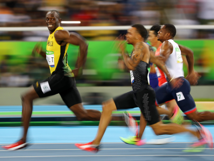 Usain Bolt of Jamaica looks at Andre De Grasse of Canada as they compete in the Men