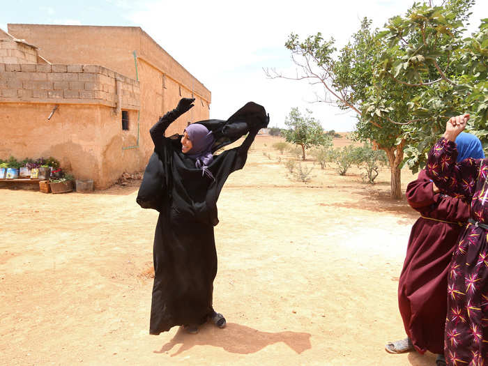 This amazing image shows a Syrian woman throwing off her niqab after her home village was freed from ISIS. Women living under ISIS