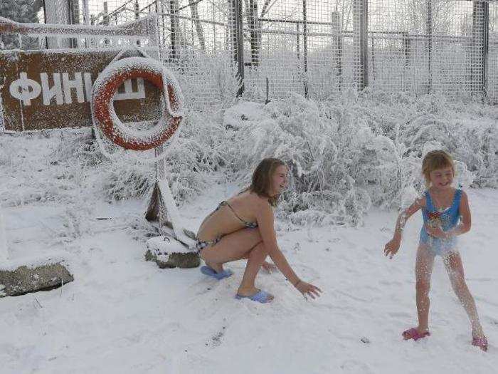 Two sisters play in the snow before bathing in the Yenisei River. Their entire family belongs to the Cryophile club, which claims that the cold water does wonders for your immune system and overall health.