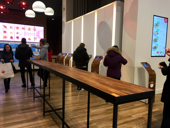 Inside, customers are immediately faced with a nontraditional set up. Instead of flocking to a single place to order and pay, about a dozen kiosks are set up along the side of the store. It almost resembles an Apple store with its long, sleek tables and minimalist style.