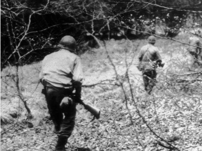 Troops from the American First Army cautiously search a wooded area in Belgium during the Battle of the Bulge, December 24, 1944, during World War II. They were looking for German parachute troops.