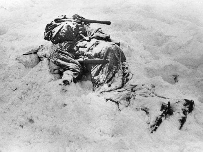 A seriously injured GI lays in the snow in Belgium, December 1944.