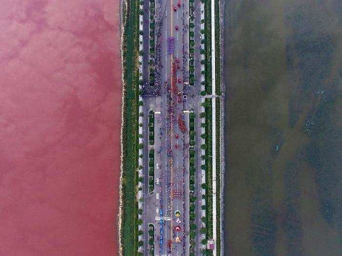 A salt lake, which is separated by a road, shows different colors due to algae. This photo was taken in Yuncheng, Shanxi Province, China, on September 25.
