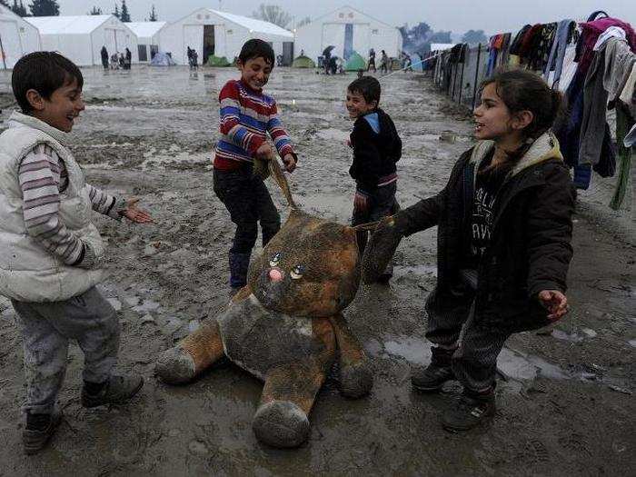 Refugee children play with a stuffed toy in the mud at a makeshift camp at the Greek-Macedonian border, near the village of Idomeni, Greece, on March 15.