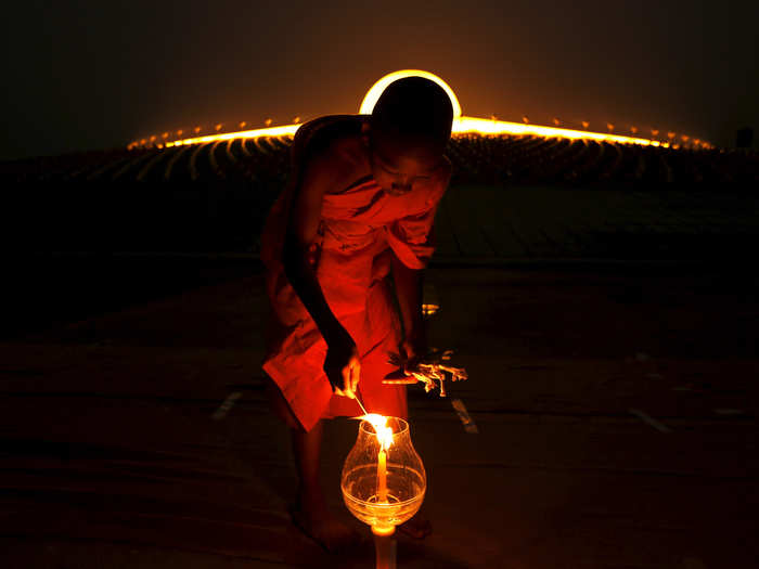 A Buddhist monk lights a candle at Wat Phra Dhammakaya during a ceremony on Makha Bucha Day in Pathum Thani province, north of Bangkok, on February 22.