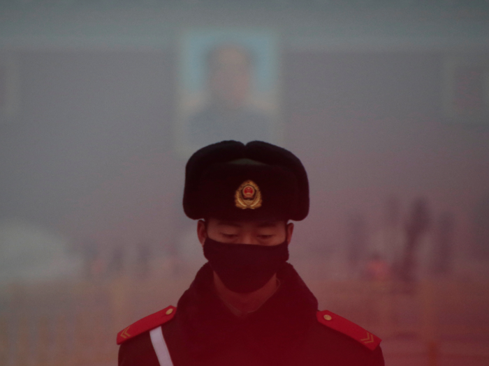 A paramilitary police officer wearing a mask stands guard in front of a portrait of the late Chairman Mao Zedong during smog at Tiananmen Square. Only the silhouettes of people standing further away could be been in the photos.