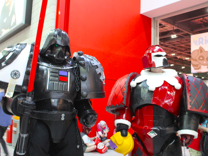 Some people meshed their favourite characters into a unique concoction. On the left, someone melded Darth Vader into a "Warhammer" space marine soldier while a girl on the right combined Harley Quinn with a space marine soldier — both creating over 8 feet high cosplay outfits.