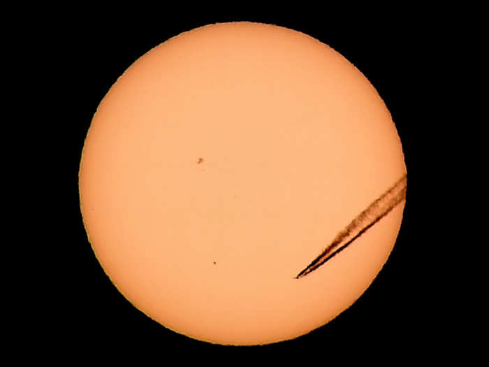 A jet airliner left a vapor trail in front of Mercury as it transited across the face of the sun in Las Vegas, Nevada. The planet passes between Earth and the sun only about 13 times a century, with the previous transit taking place in 2006.