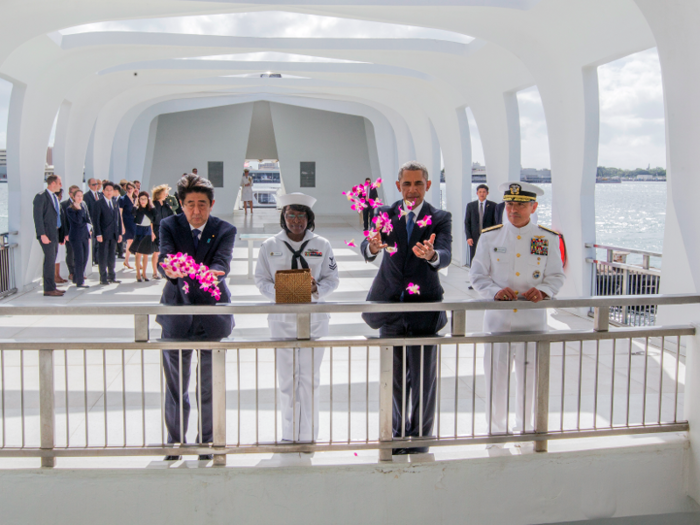 Abe and Obama toss flower petals into the Wishing Well at the USS Arizona Memorial.