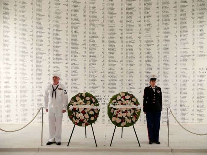 Members of an honor guard stand at attention following a wreath-laying ceremony aboard the USS Arizona Memorial, the resting place of 1,102 of 1,177 sailors and Marines killed on board.