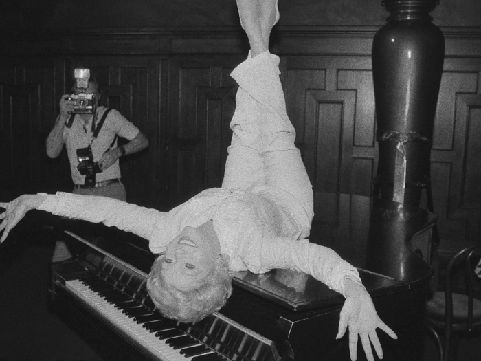 Reynolds poses on a grand piano at a New York restaurant, as she promotes the revival of the hit musical "The Unsinkable Molly Brown" on Sept. 8, 1982.