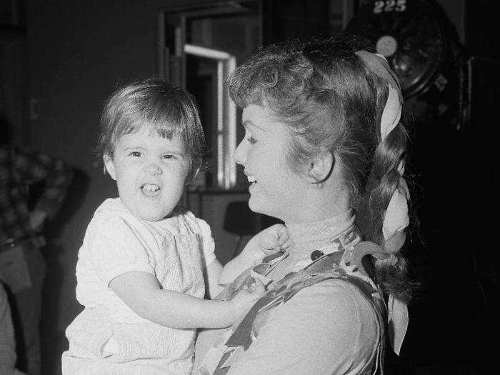 Reynolds, holding two-year-old Carrie on Feb. 21, 1959, says she wishes Eddie Fisher and Elizabeth Taylor every happiness together. The then-26-year-old star said she was happy concentrating on her children and her acting.